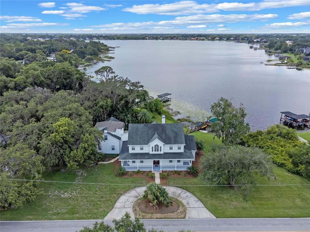 an aerial view of a house with a garden and lake view