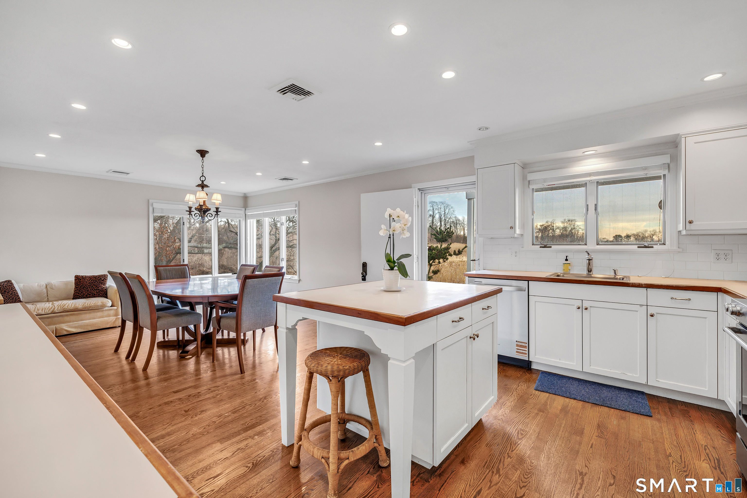 139 Field Point Drive, Unit 139 Fairfield, CT 06824 - Photo 16 of 34 a kitchen with a dining table chairs stove and white cabinets