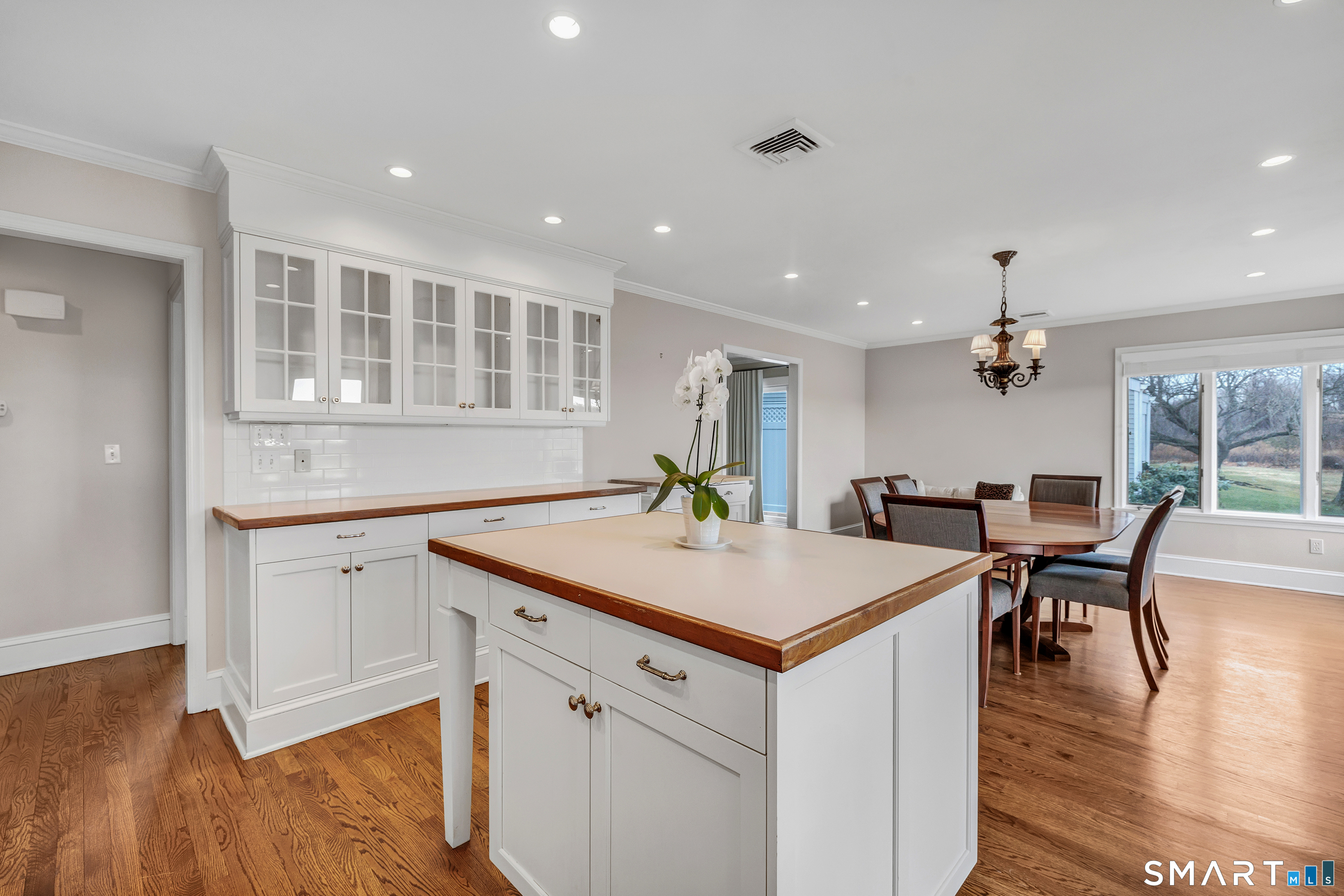 139 Field Point Drive, Unit 139 Fairfield, CT 06824 - Photo 17 of 34 a kitchen with a table chairs and wooden floors