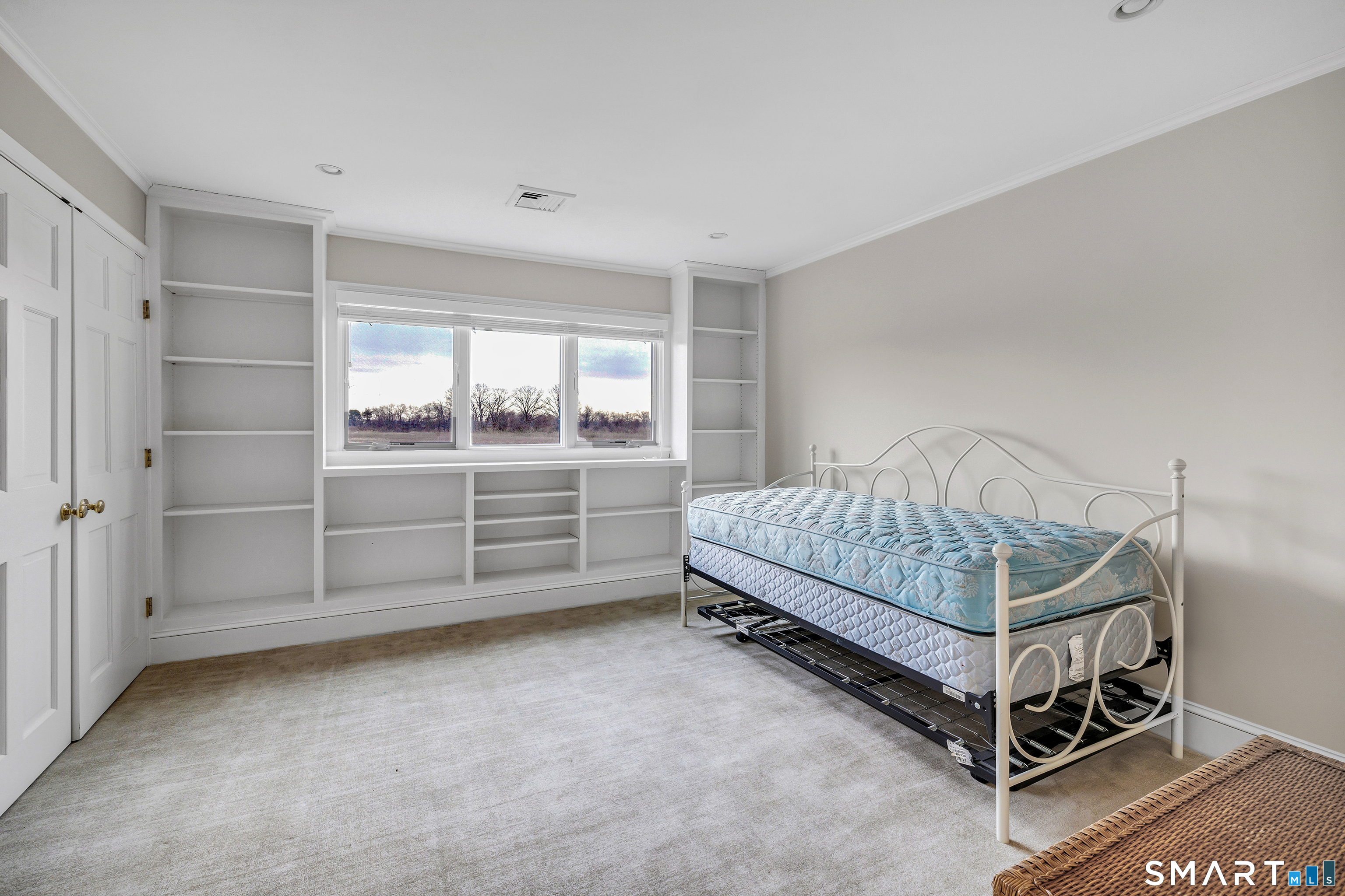 139 Field Point Drive, Unit 139 Fairfield, CT 06824 - Photo 25 of 34 a bedroom with a bed and cabinet