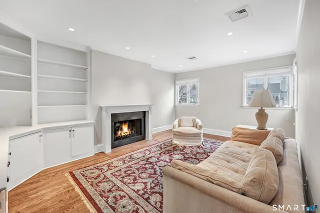 a living room with couches and cabinets with wooden floor