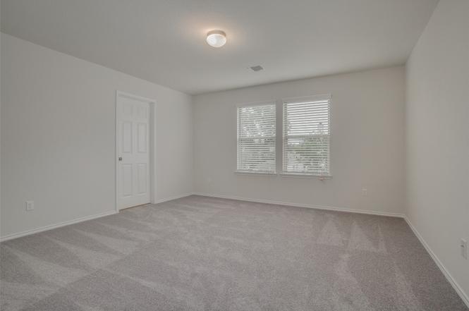 148 Spotted Rail Ridge Leander, TX 78641 - Photo 13 of 31 A spacious, naturally illuminated room featuring plush carpeting and a pair of windows.