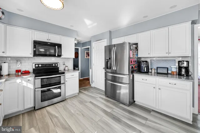 a kitchen with stainless steel appliances and white cabinets