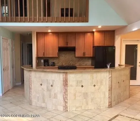 a kitchen with stainless steel appliances granite countertop a refrigerator and a stove top oven