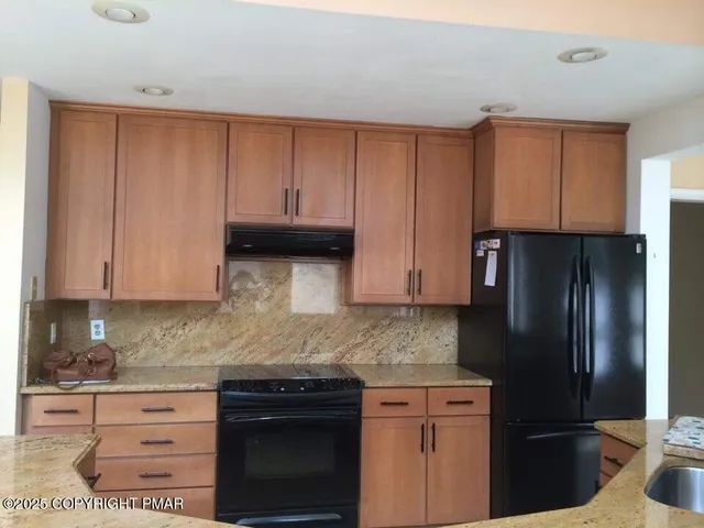 a kitchen with stainless steel appliances granite countertop a refrigerator stove and cabinets