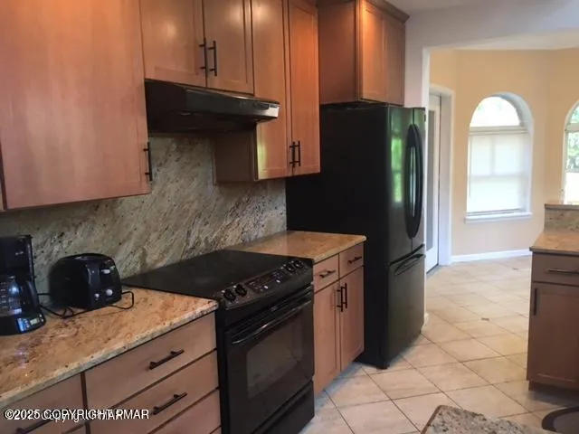 a kitchen with granite countertop a stove and a refrigerator