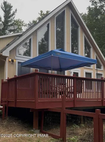 a view of a house with a deck and a yard