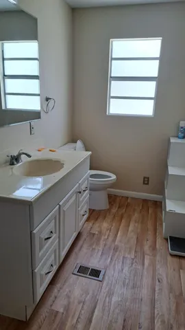 a bathroom with a sink a toilet and a window