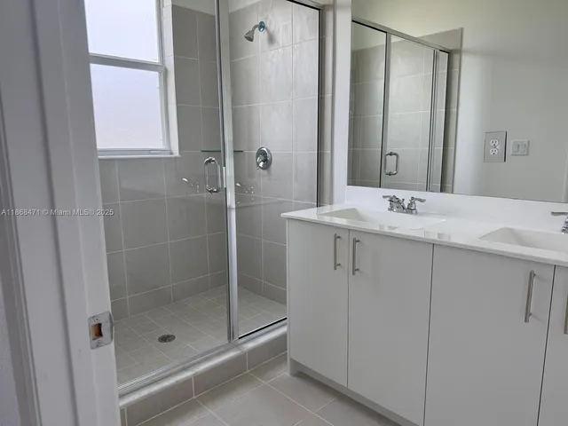 a bathroom with a shower sink and mirror