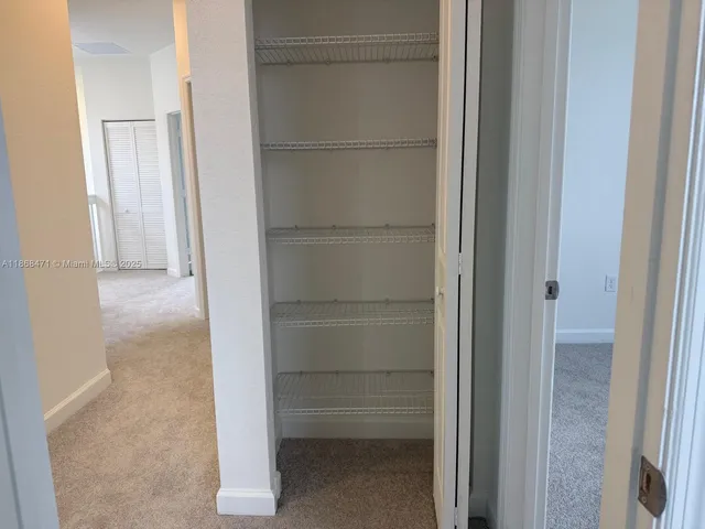 a view of walk in closet with empty racks