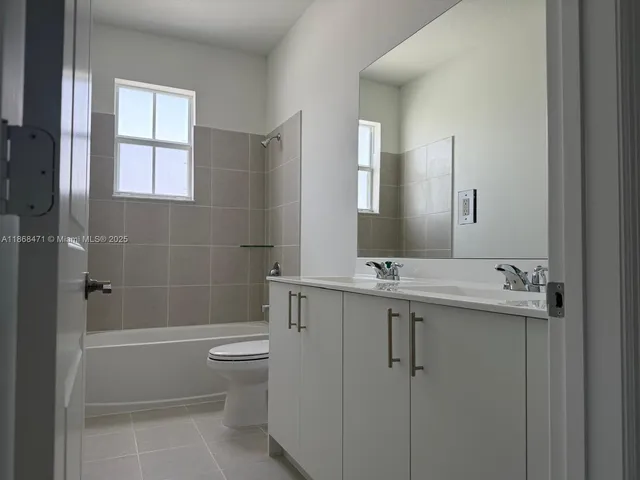 a bathroom with a granite countertop sink a toilet and shower