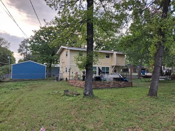 a front view of a house with garden and trees