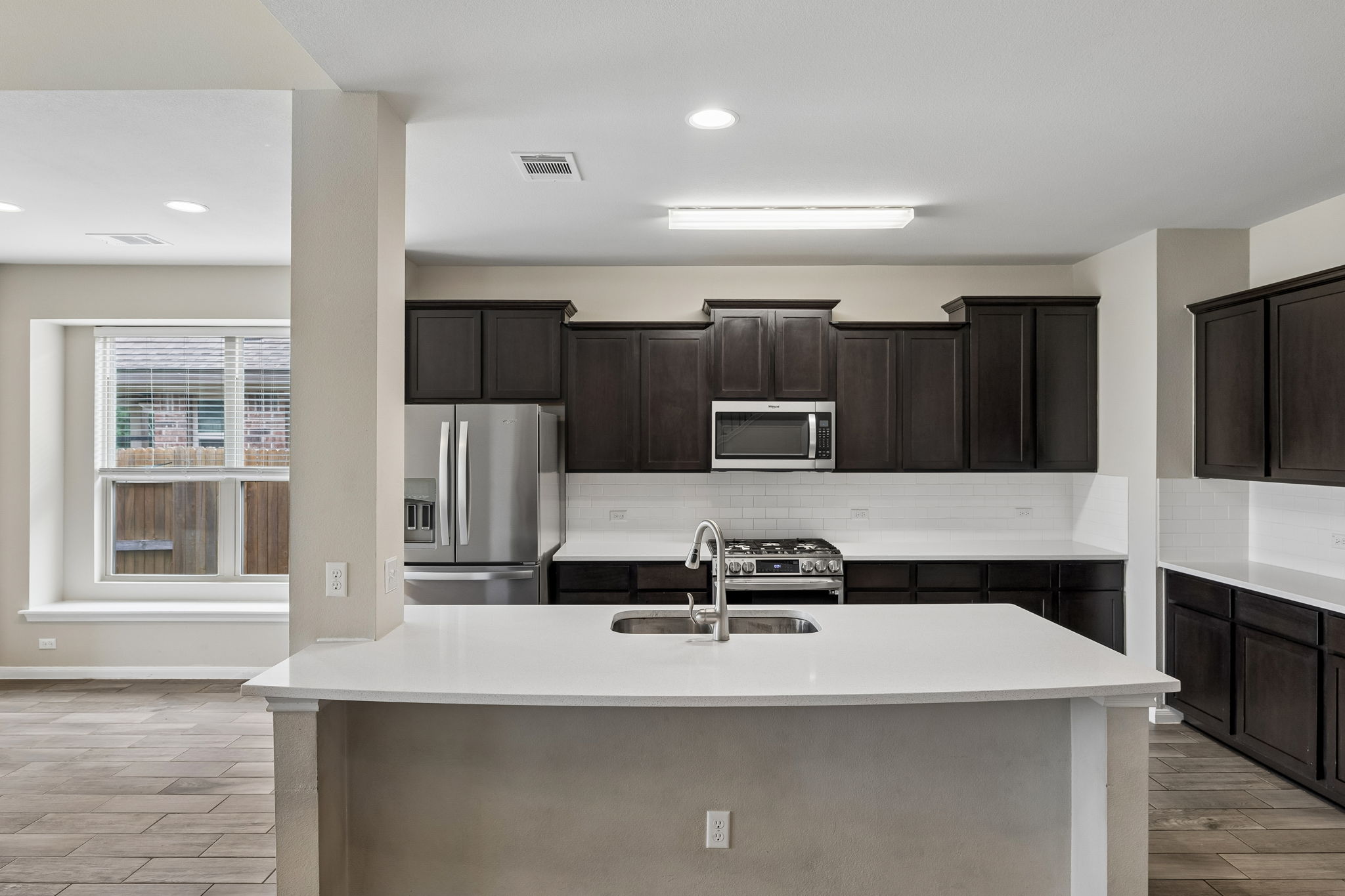 301 Rimrock Court Bastrop, TX 78602 - Photo 7 of 21 A streamlined kitchen design with dark cabinetry contrasts beautifully with white countertops and bright tile.