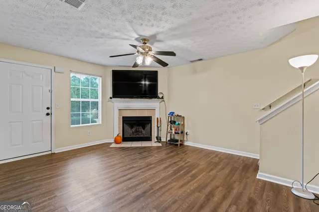 a view of a livingroom with a fireplace wooden floor and windows