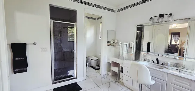 a bedroom with a bed a mirror and a large window