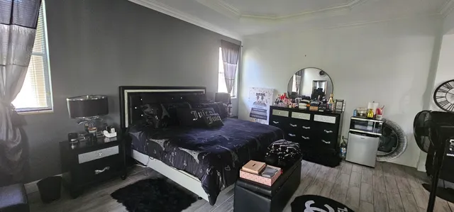 a bed sitting in a bedroom next to a window and a flat screen tv