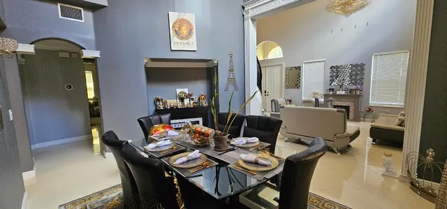 a dining room with furniture a chandelier and wooden floor