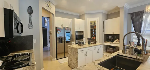 a kitchen with stainless steel appliances granite countertop a refrigerator and a stove top oven