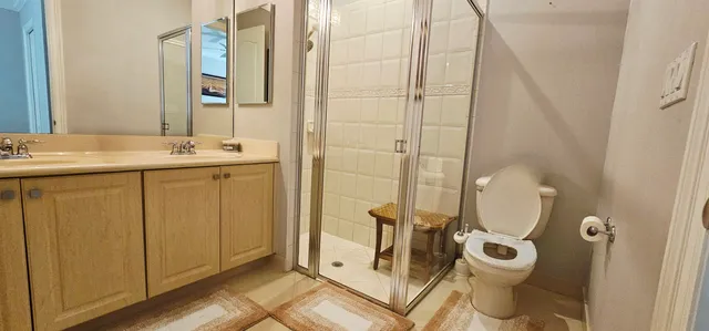 a bathroom with a granite countertop sink a toilet and shower