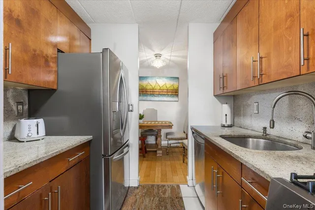 a kitchen with stainless steel appliances granite countertop a sink and a refrigerator