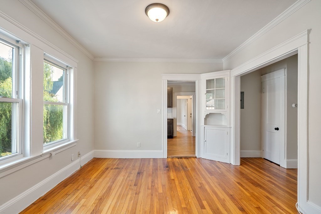 193 Florence Street, Unit 1 Boston, MA 02131 - Photo 9 of 16 a view of empty room with wooden floor and fan