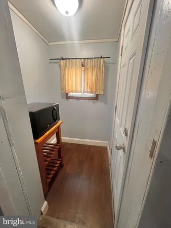 a view of a hallway with wooden floor and stairs