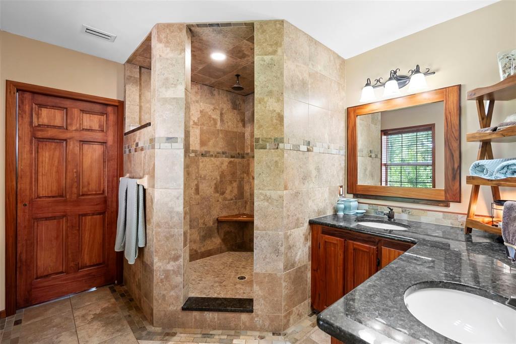 1056 Reynolds Road De Leon Springs, FL 32130 - Photo 23 of 74 a bathroom with a granite countertop sink a mirror and a shower
