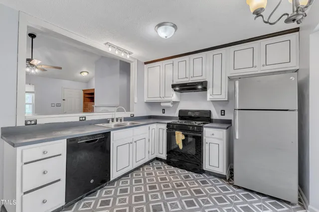 a kitchen with granite countertop a sink a stove and cabinets