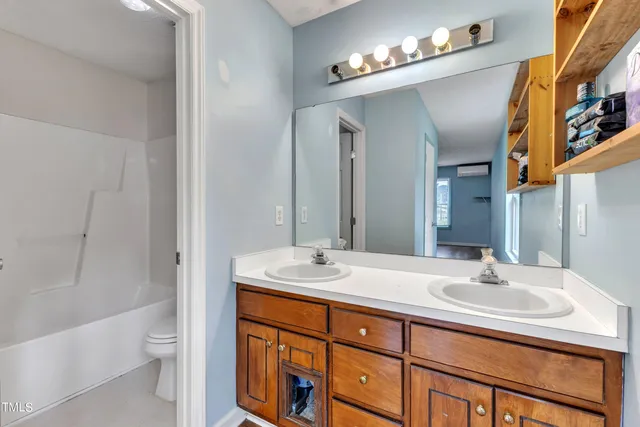 a view of a livingroom with a chandelier fan and windows