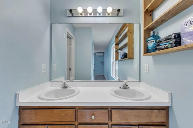 a view of a wooden house with a small yard and wooden fence