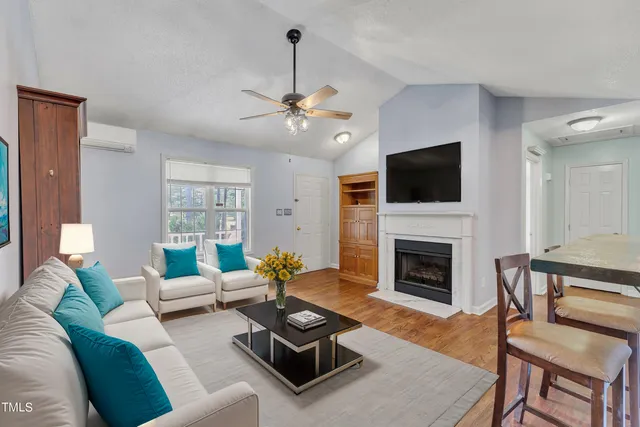 a view of a livingroom with a fireplace a ceiling fan a fireplace and entryway