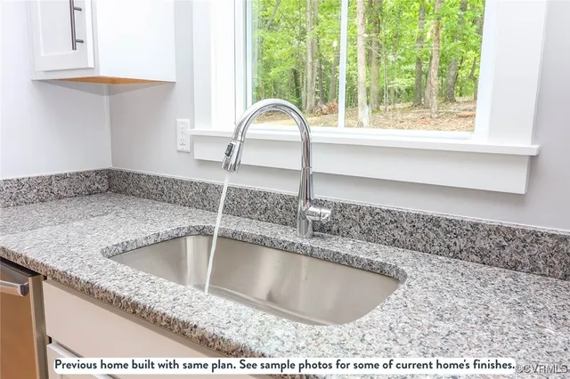 a kitchen with granite countertop a stove a sink and a microwave