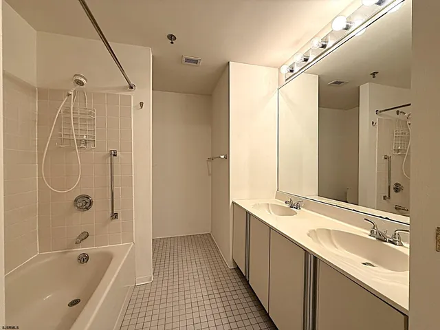 a bathroom with a tub sink shower and a mirror