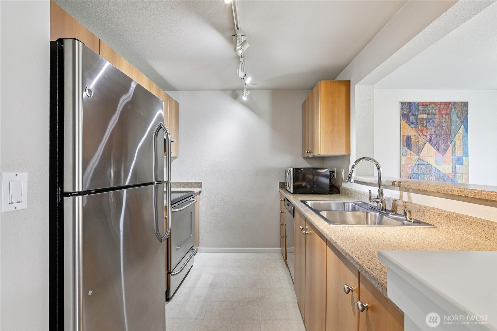 12404 East Gibson Road, Unit N203 Everett, WA 98204 - Photo 7 of 28 a kitchen with stainless steel appliances a refrigerator sink and cabinets