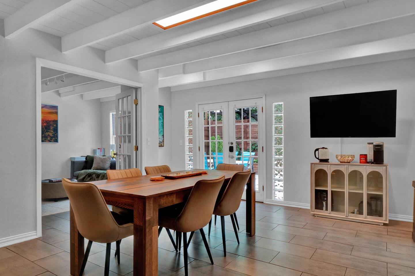 Dining area with french doors, beam ceiling, and wood finish floors