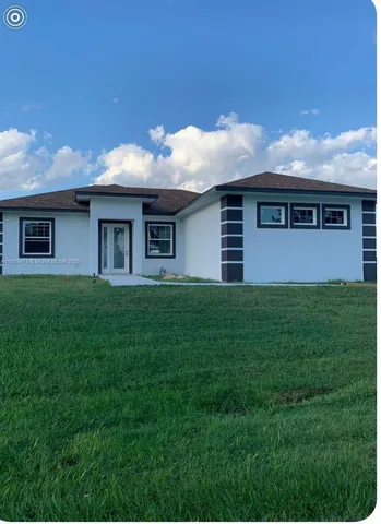 a front view of house with a garden