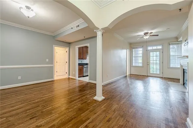 an empty room with wooden floor and windows