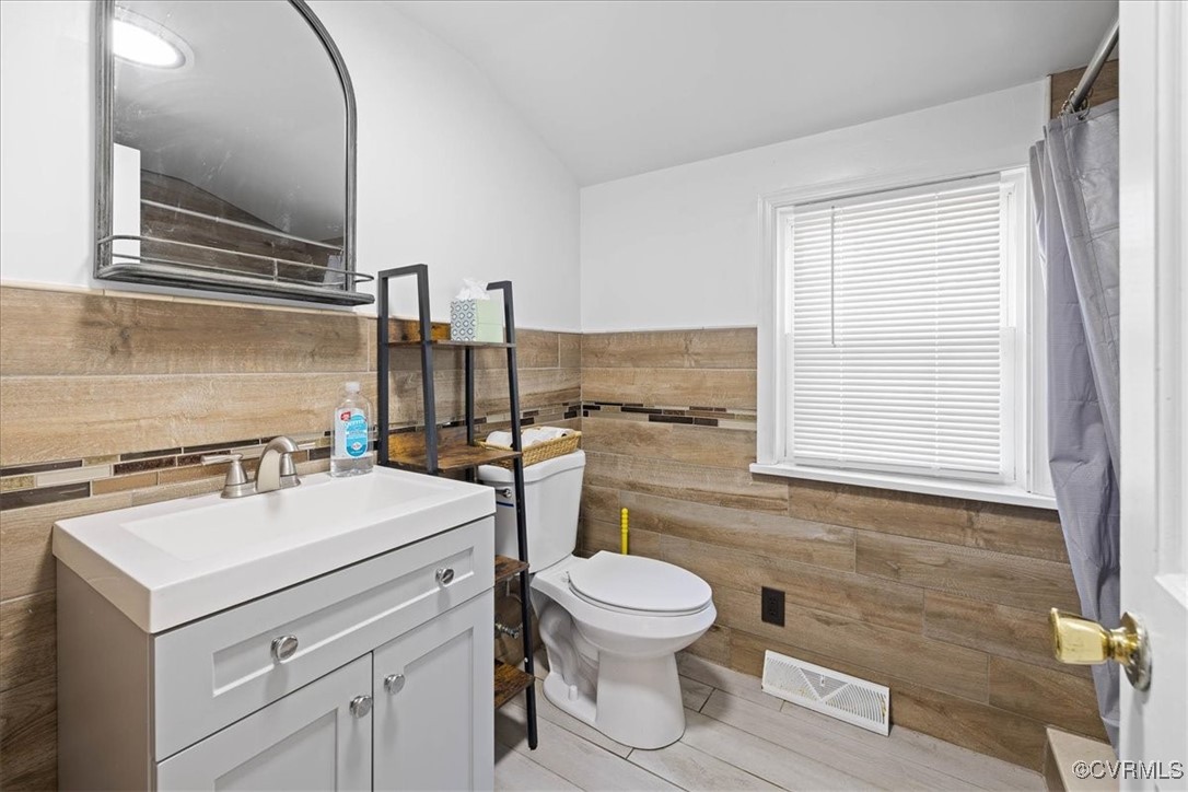 35161 Owens Grove Road Waverly, VA 23890 - Photo 9 of 35 Bathroom with tile walls, toilet, vanity, wainscot