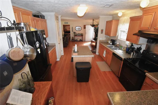 a kitchen with a sink a counter space appliances and cabinets