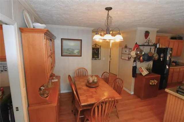 a view of a dining room with furniture a chandelier and wooden floor