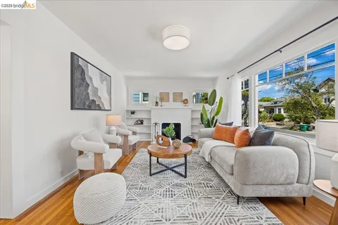 a living room with furniture a large window and a fireplace