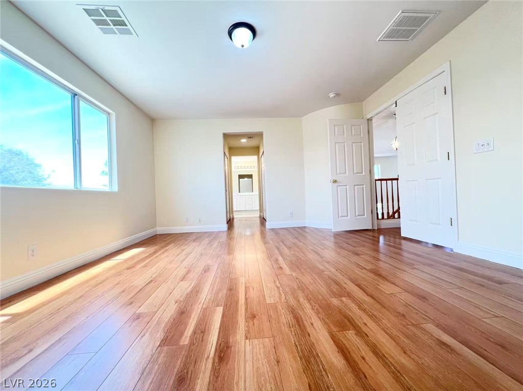9891 Ridge Hill Avenue Las Vegas, NV 89147 - Photo 15 of 29 Naturally illuminated by a broad window, this generous room features warm hardwood floors and a fresh, inviting atmosphere.