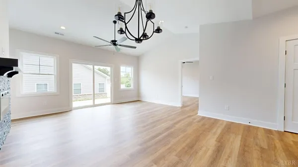a view of an empty room with wooden floor and windows