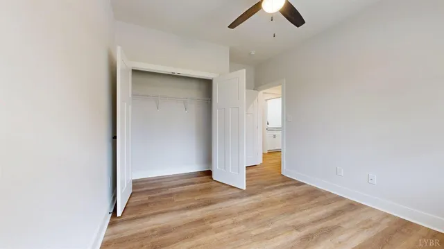 an empty room with wooden floor and window