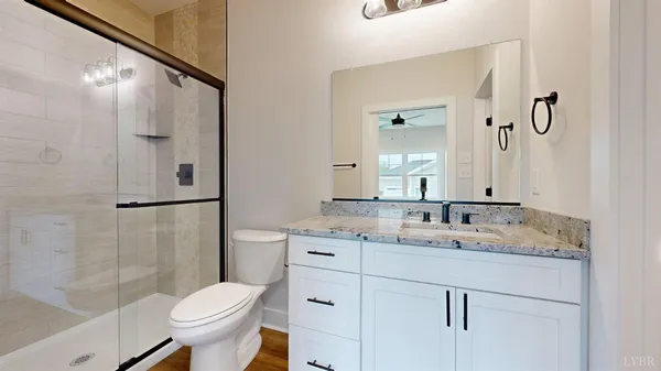 a bathroom with a granite countertop sink toilet and shower