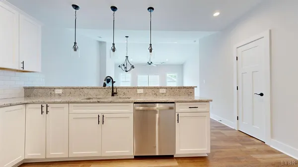a kitchen with a sink cabinets and wooden floor