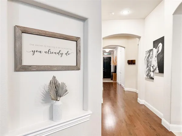 a view of a hallway with wooden floor and a potted plant