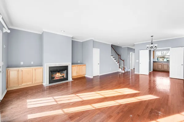 a view of a livingroom with wooden floor and a fireplace
