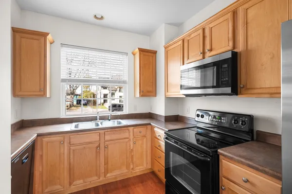 a kitchen with stainless steel appliances cabinets sink and window