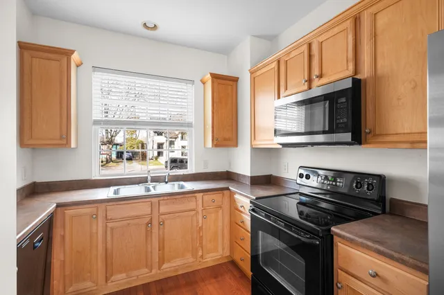 a kitchen with stainless steel appliances cabinets sink and window
